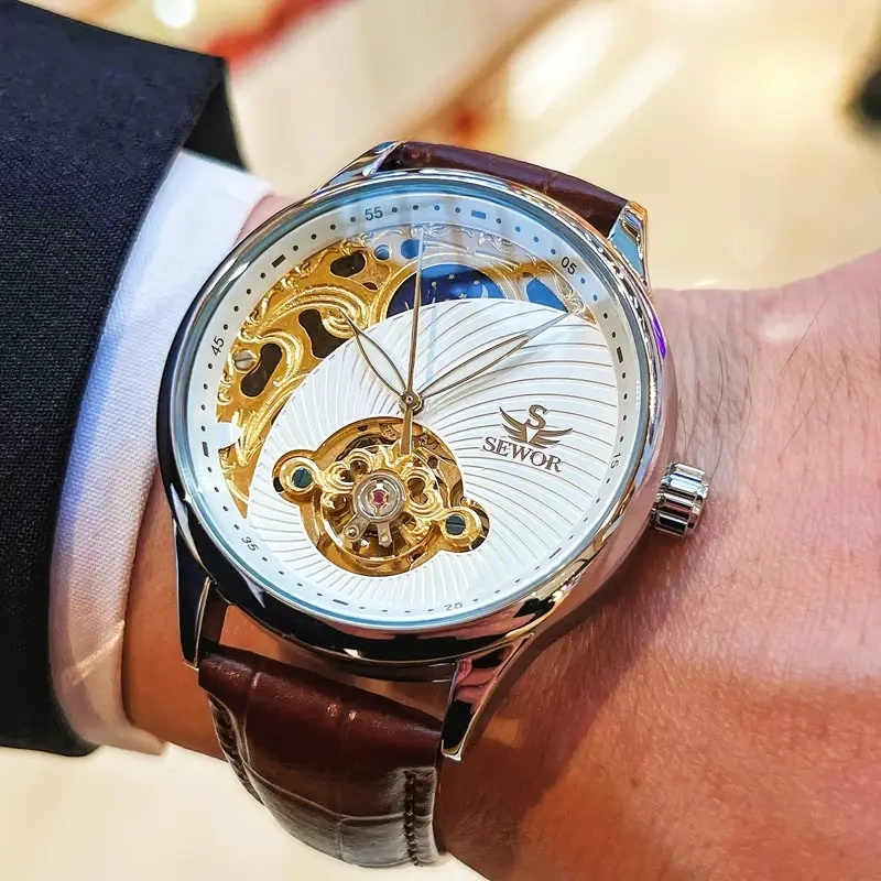 Luxury Watch It - นาฬิกาข้อมืออัตโนมัติสำหรับผู้ชายสุดหรู ดีไซน์โครงกระดูก ผสมผสานความสง่างามและความทันสมัย นาฬิกาข้อมือนี้โดดเด่นด้วยดีไซน์โครงกระดูกทูร์บิญองและดีไซน์รูปพระจันทร์ครึ่งเสี้ยว ทำให้เป็นของขวัญในอุดมคติในช่วงวันหยุดและงานสังสรรค์ทางธุรกิจ แสดงให้เห็นถึงความสวยงามแบบย้อนยุคแต่ก็ทันสมัยในสไตล์ธุรกิจ